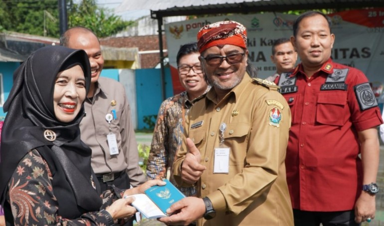 Bupati Temanggung Agus Setyawan ketika memberikan paspor kepada salah satu pemohon di wilayahnya. Foto : emhaka putra/kuasakata.com