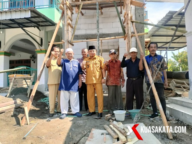 Kepala Desa Kalimati, Lukmanul Hakim SE dan Bendahara Panitia H Jamali beserta sejumlah panitia berfoto bersama dengan latar belakang pembangunan menara Masjid Jami Ruhama. Foto. Eko S/kuasakakata.com